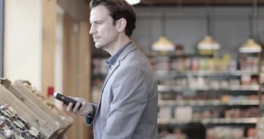 Yetişkin bir erkek markette kendini tarıyor.