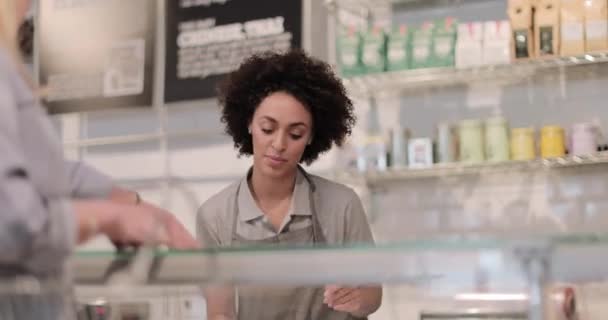 Assistente de vendas servindo cliente em um balcão deli — Vídeo de Stock