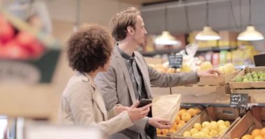 Bir çift gece yarısı market alışverişi ve akıllı telefon kullanıyor.