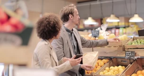 Paar nachtelijke boodschappen doen en smartphone gebruiken — Stockvideo