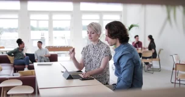 Коллеги на совещании смотрят на цифровой планшет — стоковое видео