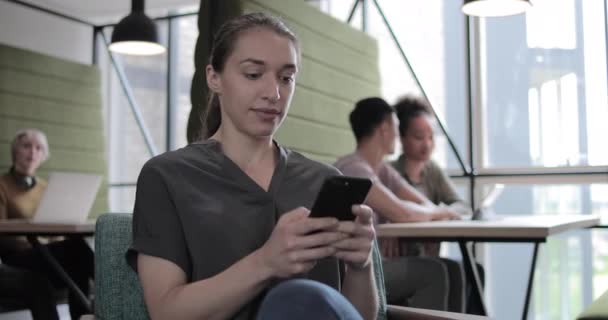 Wanita Hispanik menggunakan smartphone dalam ruang kerja sama — Stok Video