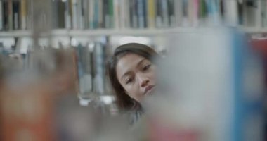 Asya kadın üniversite kütüphanesi kitap arıyor