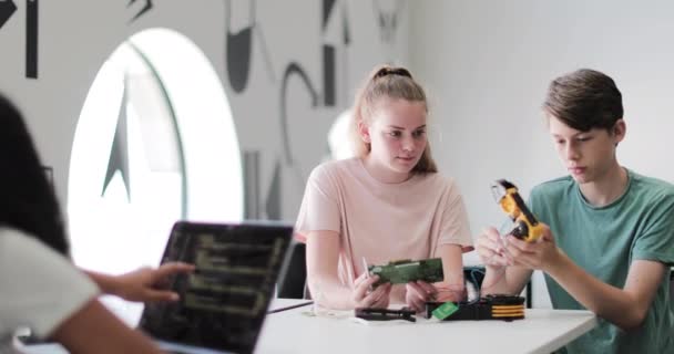 Étudiants du secondaire travaillant sur un bras robotique en classe — Video