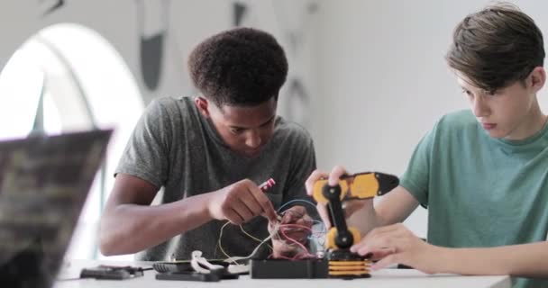 Estudiantes de secundaria trabajando en un brazo robótico en clase — Vídeo de stock
