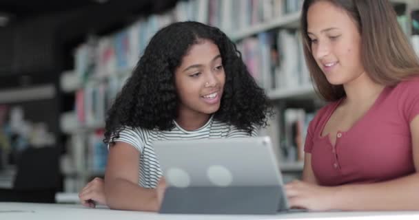 Estudantes do ensino médio do sexo feminino estudando com tablet digital na biblioteca — Vídeo de Stock