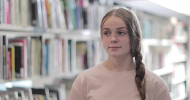 Retrato del estudiante de secundaria en la biblioteca — Vídeos de Stock