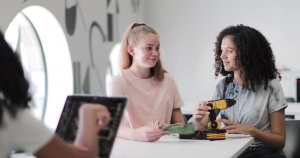 Gymnasieelever som arbetar på en robotarm i klass — Stockvideo