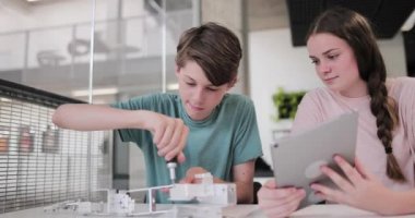 Lise öğrencileri sınıfta bir robot kol üzerinde çalışıyor