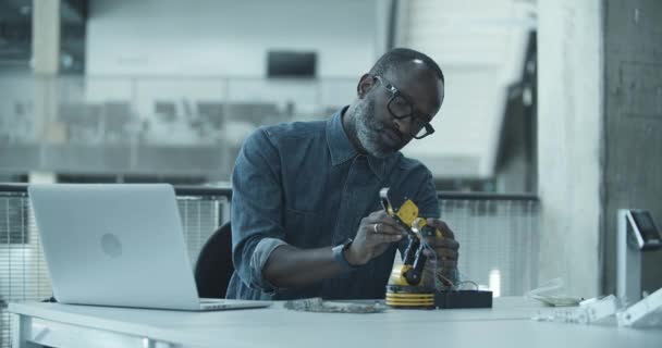 Afro-Américain adulte mâle travaillant sur la robotique — Video