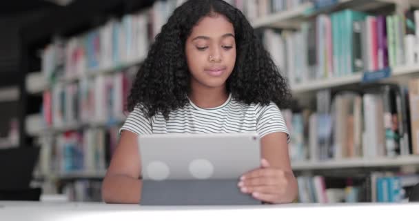 High school afrikanska amerikanska kvinnliga student studerar med digital surfplatta i biblioteket — Stockvideo