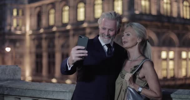 Senior Adult Par tar selfie framför Opera på kvällen ut — Stockvideo