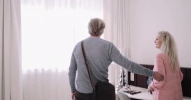 Üst düzey yetişkin çift tatil için otel odasına giriyor.