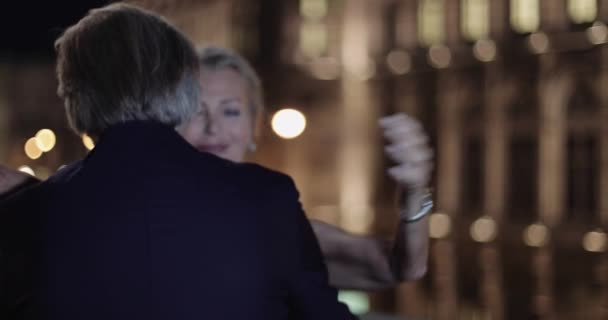 Casal adulto sênior abraçando na noite romântica na frente da casa de ópera — Vídeo de Stock