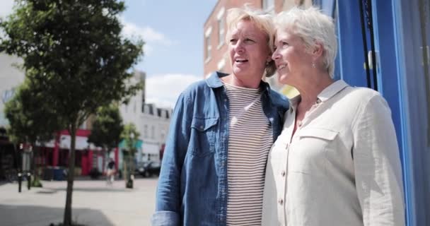 Volwassen lesbisch paar op high street in de zomer — Stockvideo