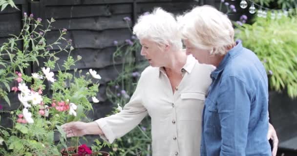 Volwassen lesbisch paar in tuin samen — Stockvideo