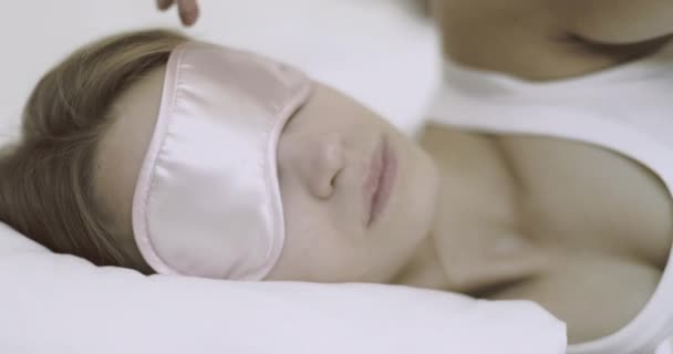 Pretty young adult woman sleeping in hotel bedroom with eye mask — Stock Video