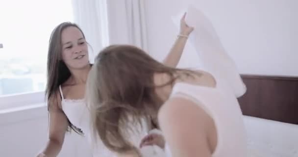 Jovens meninas adultas tendo travesseiro luta no quarto — Vídeo de Stock