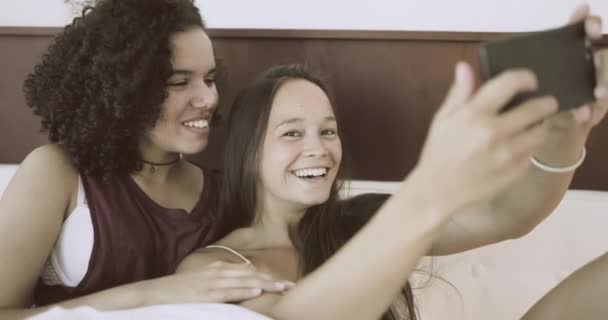 Lezbiyen çift yatak odasında akıllı telefonlarıyla selfie çekiyor. — Stok video