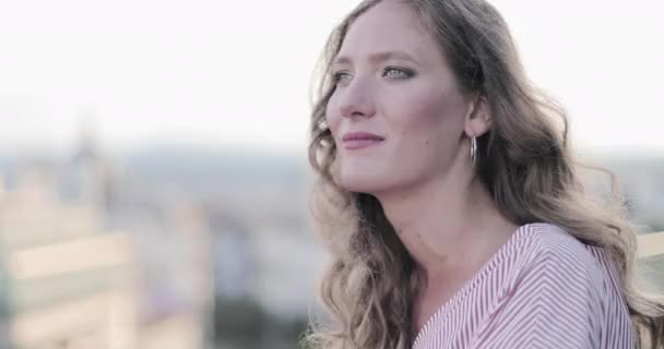 Erwachsene Frau blickt bei Sonnenuntergang vom Hotelbalkon auf die Stadt — Stockvideo
