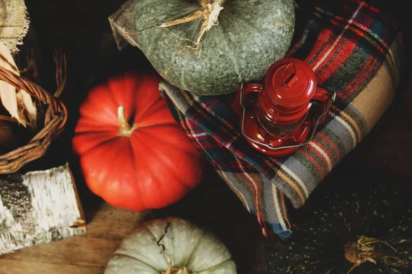 Pumpkins, plaid and a kerosene lamp on a wooden background. Harvesting. Thanksgiving Day. Wallpaper