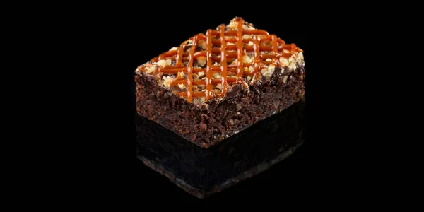 Siyah arka planda fındıklı ve şuruplu kek yansıması ile izole edilmiş. E-ticaret çekimi