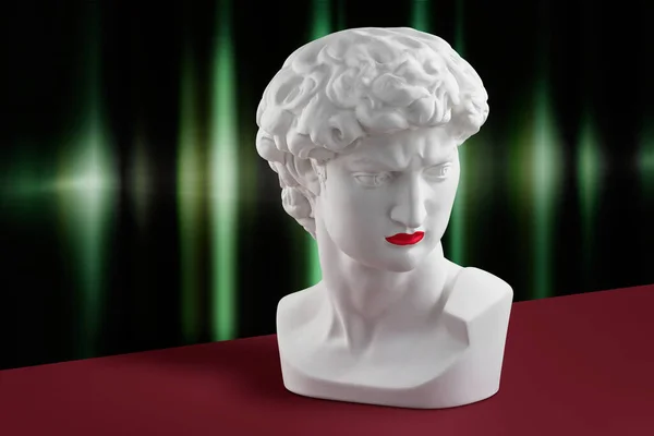 Kırmızı rujlu Gypsous David heykeli arka planda zümrüt yeşili perdeler ve koyu kırmızı yüzeyde duruyor. Moda, ihtişam, antika görünüş           