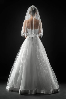 Uzun, güzel, beyaz bir gelinlik ve dantelli bir duvak içinde gelin. Siyah arkaplan