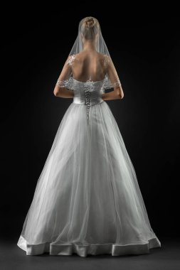 Uzun, güzel, beyaz bir gelinlik ve dantelli bir duvak içinde gelin. Siyah arkaplan