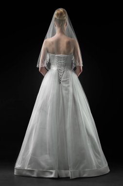 Uzun, güzel, beyaz bir gelinlik ve dantelli bir duvak içinde gelin. Siyah arkaplan