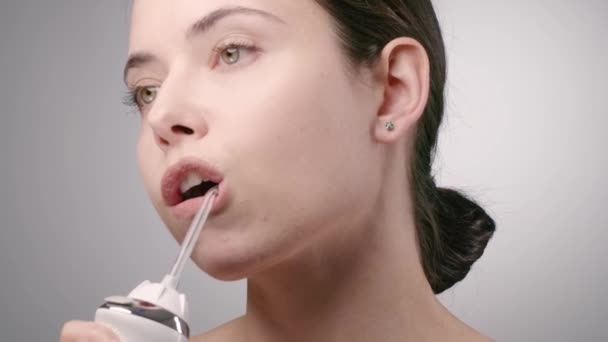 Jeune brune nettoyer les dents avec du fil d'eau — Video