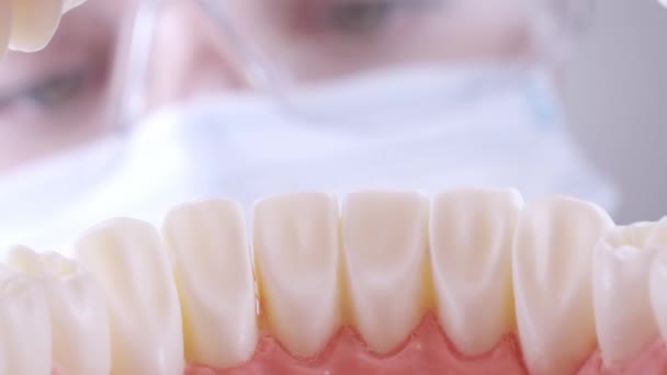 Tandläkare sätter på glasögon och inspekterar tänder — Stockvideo