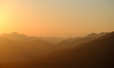 Sis ve tepe noktalarıyla güzel dağ günbatımı