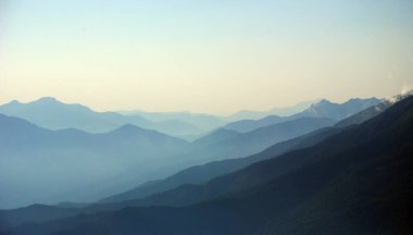 Sis ve tepe noktalarıyla güzel dağ günbatımı