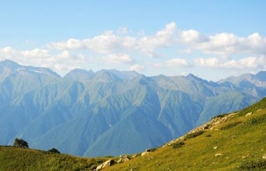 Yeşil çimenli ve mavi gökyüzü olan dağlar. Korkunç bir doğa.