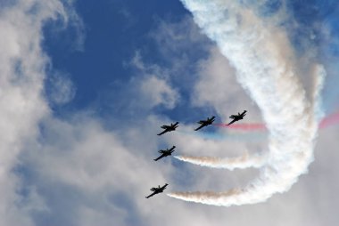 Mavi gökyüzüne karşı dumanlı uçaklar