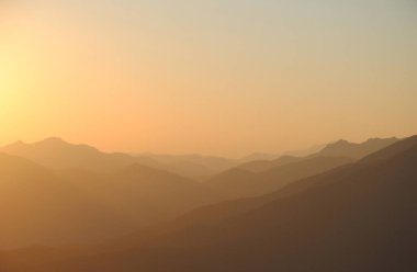 Dağlarda gün batımı. Tepeler ve tepeler güzel gökyüzüne karşı