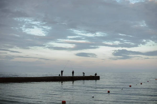 Balıkçılar Iskelede Deniz Gökyüzünün Arka Planında Balık Yakalıyorlar — Stok fotoğraf