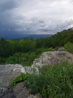 Fırtına bulutları dağılıyor ve güneş aşağıdaki topraklara doğru parlıyor..