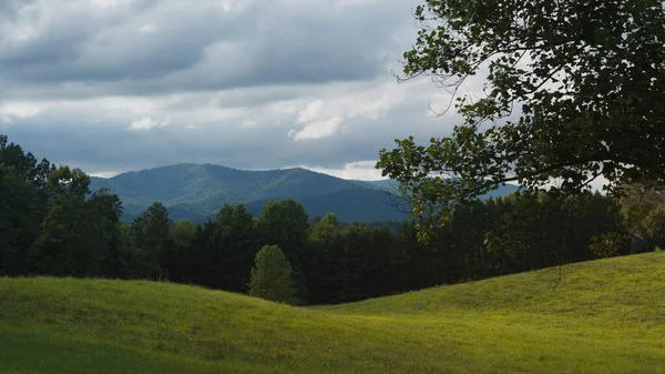 Colorful clouds above the beautiful Blue Ridge Mountains with a green meadow in the foreground
