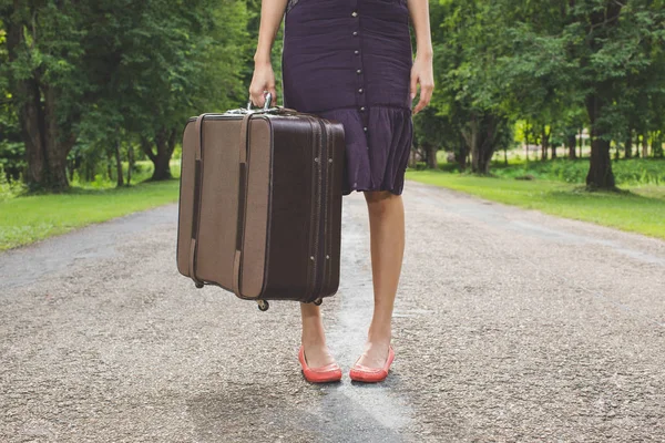 woman with retro vintage luggage on empty street