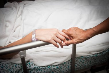 Eski kırışmış el dokunur ve Genç elini tutar