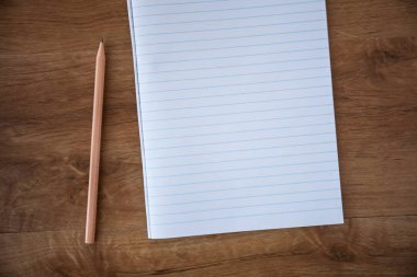 Boş defter kalem üzerinde ahşap masa, iş kavramı ile