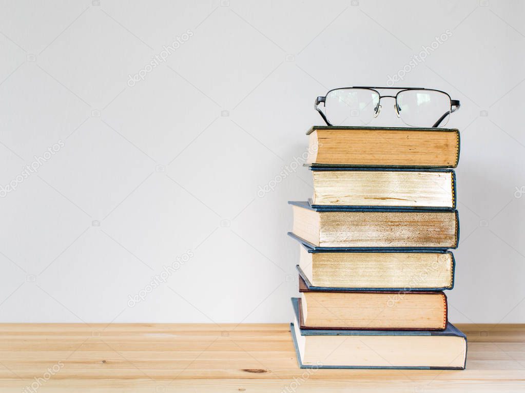 A lot of books for studying and black glasses