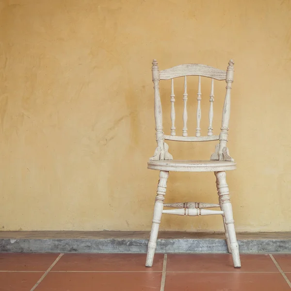 Vintage tone of white Vintage chair near yellow old wall