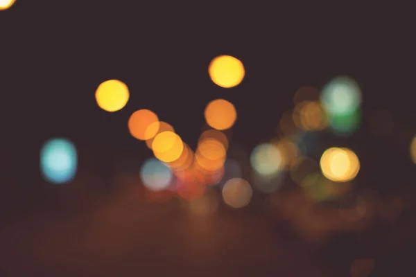 Vintage tone of Bright circles from streetlamps on defocused photo of night street.