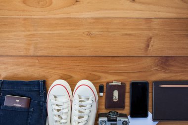 Gezgin, öğrenci, genç, genç kadın veya adam kıyafeti. İn gerekli modern genç kişi için ek yükü. Ahşap arka plan üzerinde farklı nesneleri.