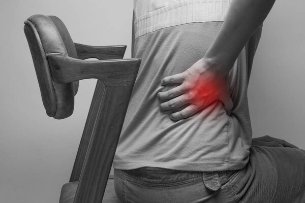 Businesswoman holding his hand to her aching back