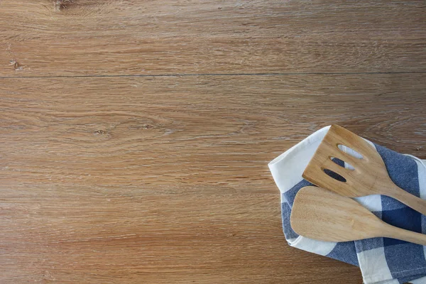 Деревянные кухонные принадлежности и постельное белье кухонные полотенца на светлой столешнице — стоковое фото