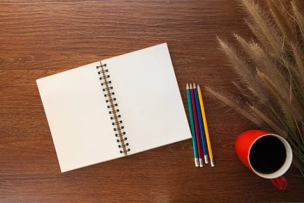 Notebook, pen en kopje koffie op houten tafel — Stockfoto